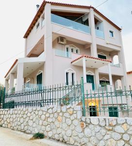 a white building with a fence in front of it at The mulberry apartment in Korfos