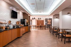 a dining room with tables and chairs and a kitchen at Fairfield Inn by Marriott Evansville West in Evansville