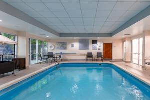 a swimming pool in a large room with chairs and tables at Fairfield Inn by Marriott Evansville West in Evansville
