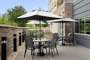 eine Terrasse mit Tischen, Stühlen und Sonnenschirmen in der Unterkunft Fairfield Inn & Suites by Marriott Boise West in Boise