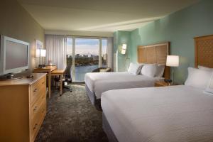 a hotel room with two beds and a flat screen tv at Courtyard by Marriott Fort Lauderdale Beach in Fort Lauderdale