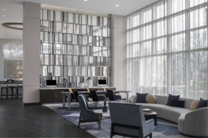 a living room with a couch and chairs and a table at AC Hotel by Marriott Charlotte Ballantyne in Charlotte