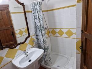 ein Badezimmer mit Waschbecken und Duschvorhang in der Unterkunft Casa El Banco in Iznate