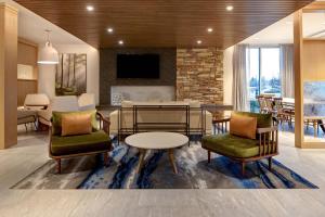 a lobby with chairs and a table and a dining room at Fairfield Inn & Suites by Marriott Chicago Bolingbrook in Bolingbrook