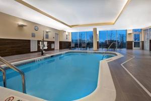 duży basen z niebieską wodą w pokoju hotelowym w obiekcie Fairfield Inn & Suites by Marriott Chicago Bolingbrook w mieście Bolingbrook
