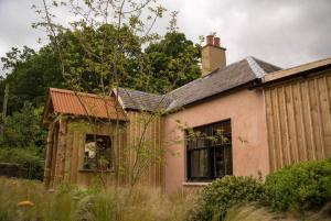 una casa vieja con una chimenea encima en The Artist's House at Jupiter Artland en Kirknewton