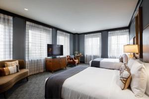 a hotel room with two beds and a flat screen tv at The Barfield, Autograph Collection in Amarillo