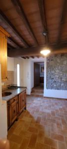 una cocina con armarios de madera y una pared de piedra. en Casa Nolè, en Santa Luce