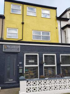 un bâtiment jaune et noir avec une clôture devant lui dans l'établissement The Lenbrook, à Blackpool