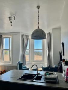 a kitchen with a sink and a pendant light at SkyLine Beautiful Apartment in Hastings