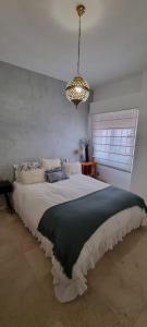 Un dormitorio con una cama grande y una lámpara de araña. en LA CASITA DE LA PUERTA DE CARMONA, en Sevilla