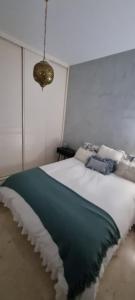 sypialnia z dużym łóżkiem z niebiesko-białym kocem w obiekcie LA CASITA DE LA PUERTA DE CARMONA w Sewilli