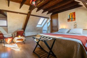 ein Schlafzimmer mit einem großen Bett in einem Zimmer mit Holzdecken in der Unterkunft Chambres Du Marais in Tilques