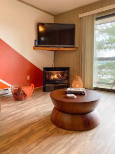 a living room with a table and a fireplace at Cozy Retreat Just Minutes From Beech Mountain in Beech Mountain