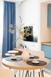 a table with two cups and a vase with flowers on it at Giada Luxury Terrasini in Terrasini
