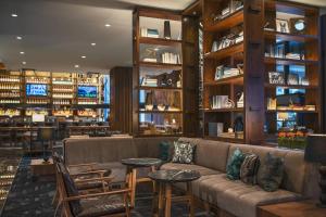 a library with a couch and tables and shelves at The Worthington Renaissance Fort Worth Hotel in Fort Worth