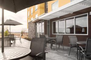 een patio met tafels en stoelen en een gebouw bij Fairfield Inn & Suites by Marriott Memphis Marion, AR in Marion