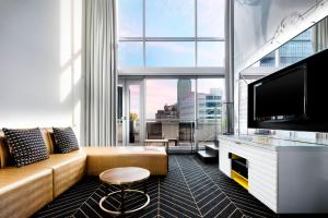 a living room with a couch and a flat screen tv at W Montreal in Montreal