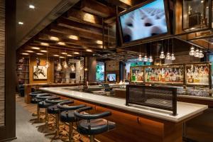 um bar com bancos e uma televisão na parede em Renaissance Phoenix Downtown Hotel em Phoenix