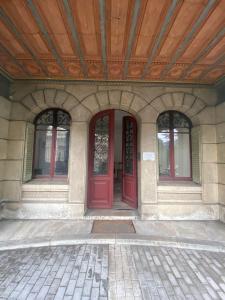 a building with two red doors and a wooden ceiling at Villa Bagatelle in Aix-les-Bains
