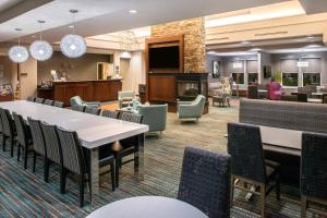 a lobby with tables and chairs and a fireplace at Residence Inn Waynesboro in Waynesboro