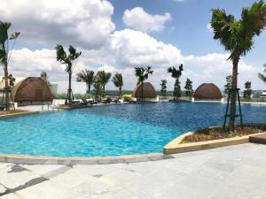 Una gran piscina con palmeras y cabañas. en Almas Suite-SS-Puteri Harbour Legoland-JB新山- SG新加坡, en Nusajaya 12 fotos más