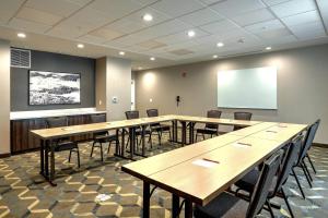 a conference room with tables and chairs and a screen at Residence Inn by Marriott Harrisburg North in Harrisburg
