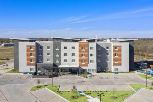 un edificio de apartamentos con un aparcamiento enfrente en TownePlace Suites Waco Northeast, en Waco