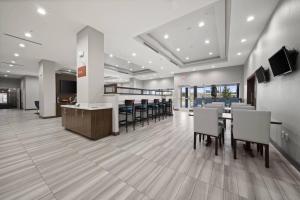 a lobby with tables and chairs and a bar at TownePlace Suites Waco Northeast in Waco