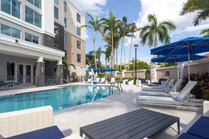 una piscina con sillas y sombrillas en un hotel en Residence Inn Palm Beach Gardens en Palm Beach Gardens