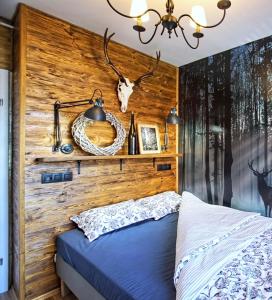 sypialnia z łóżkiem z drewnianą ścianą w obiekcie Apartament Lipova w Piechowicach