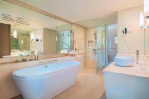 a large bathroom with a tub and a shower at Le Meridien Suvarnabhumi, Bangkok Golf Resort and Spa in Bangna