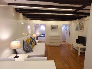 a living room with a white couch and a television at Alfama Home in Lisbon