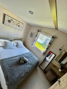 Habitación pequeña con cama y ventana en Newquay Bay Resort - SummerBreeze PV54 en Newquay Bay Resort