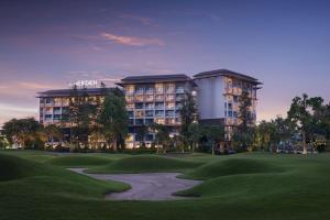 a golf course with a hotel in the background at Le Meridien Suvarnabhumi, Bangkok Golf Resort and Spa in Bangna