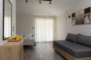 a living room with a couch and a bowl of fruit on a table at Fani Guesthouse in Paralia Katerinis