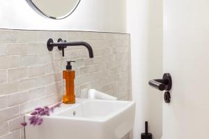 W łazience znajduje się umywalka z kranem i lustrem. w obiekcie Samaritana Suites w Palma de Mallorca