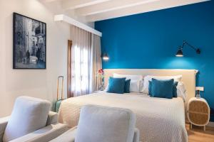 a bedroom with blue walls and a bed with two chairs at Samaritana Suites in Palma de Mallorca