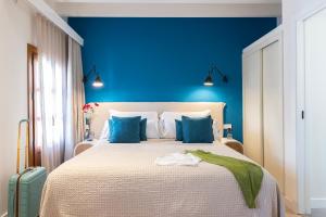 a blue bedroom with a large bed with blue walls at Samaritana Suites in Palma de Mallorca