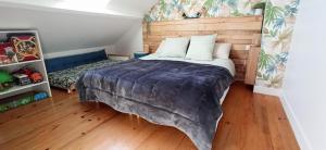 1 dormitorio con 1 cama grande y cabecero de madera en L'essentiel, proche de Disneyland Paris 2 chambres et 2 SDB, en Chessy