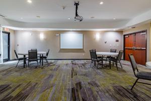 a conference room with tables and chairs and a whiteboard at Courtyard Brunswick in Brunswick