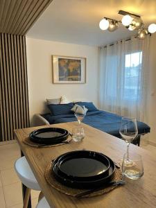 uma mesa de jantar com 2 copos de vinho e uma cama em Petit cocon en hyper-centre em Reims