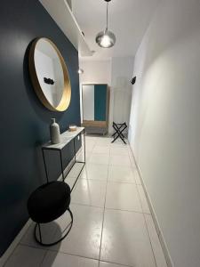 - un couloir avec un miroir et une chaise dans la chambre dans l'établissement Petit cocon en hyper-centre, à Reims