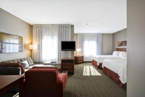 a hotel room with two beds and a flat screen tv at TownePlace Suites Sioux Falls in Sioux Falls