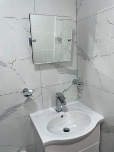 a white bathroom with a sink and a mirror at 2 bedroom near Euston, King's Cross in London