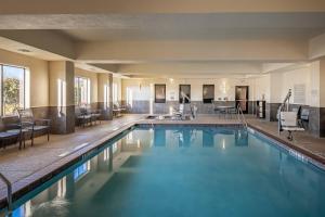 uma piscina num hotel com cadeiras e mesas em Fairfield Inn & Suites Fort Worth Northeast em Hurst