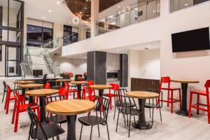 un restaurante con mesas de madera y sillas rojas en Residence Inn by Marriott Pittsburgh Oakland/University Place, en Pittsburgh