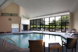 a large swimming pool with chairs and a table at Marriott Memphis East in Memphis