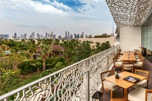 a balcony with tables and chairs and a view of the city at Bulgari Resort, Dubai in Dubai