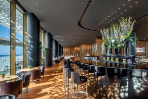 un restaurant avec un bar doté de chaises et de tables dans l'établissement Bulgari Resort, Dubai, à Dubaï